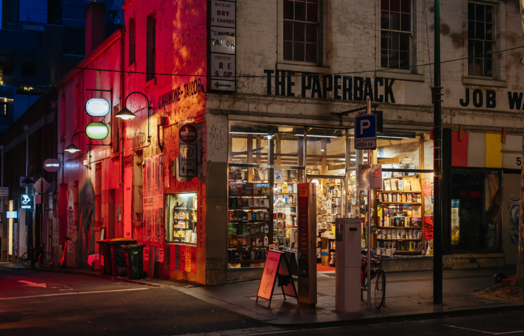 Melbourne Street Scene at Night in Australia. MELBOURNE, AUSTRALIA - FEBRUARY 16, 2022: The Iconic Paperback book shop illuminated at night on Bourke St in Melbourne CBD, Victoria, Australia