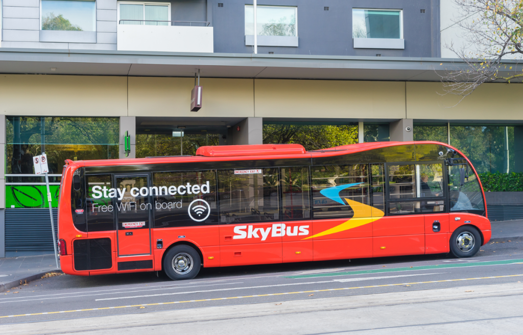 SkyBus waiting for departure outside a hotel in Melbourne. SkyBus has provided transfer service from Melbourne Airport to the city centre for over 35 years.